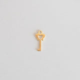 Gold key-shaped pendant on a light gray background