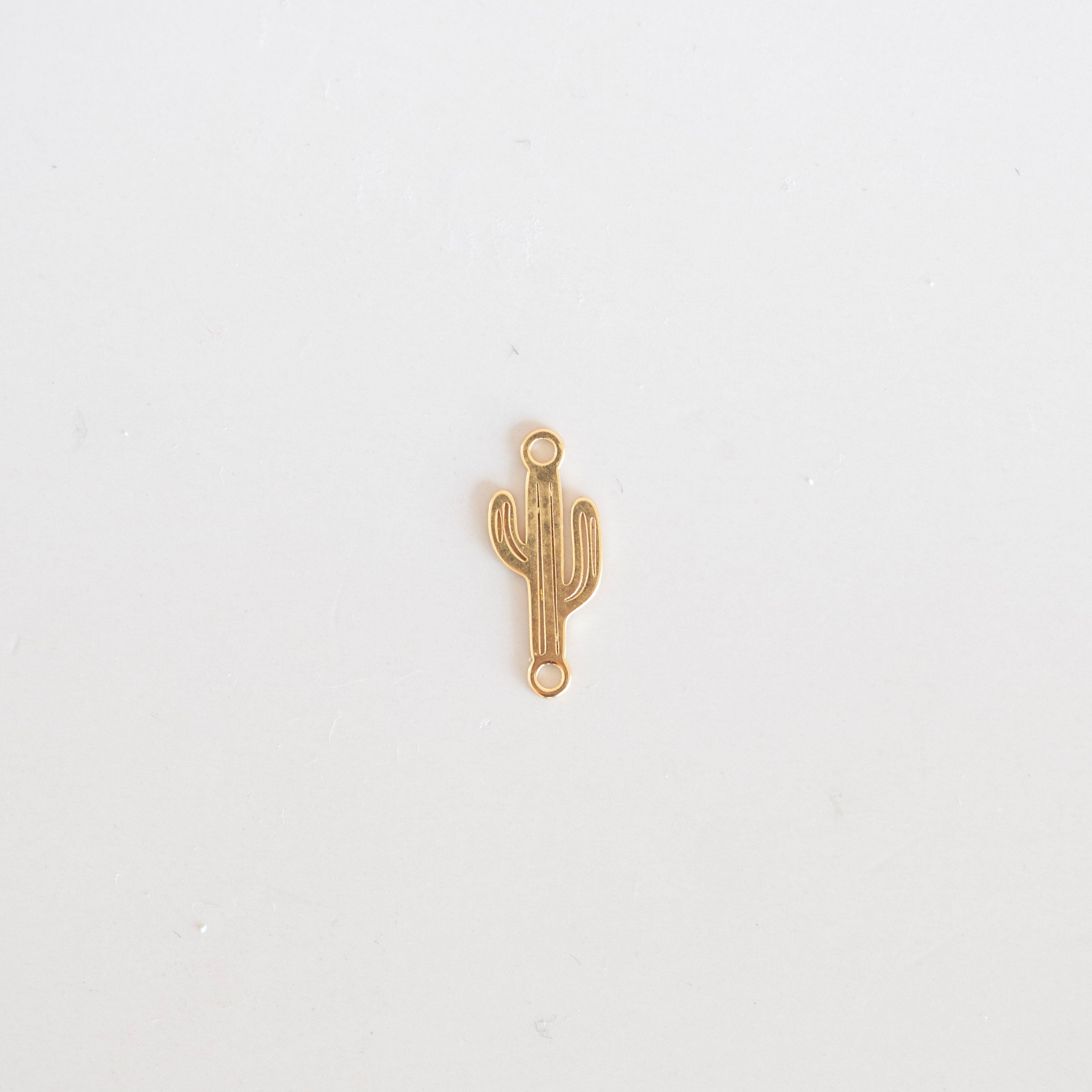 Gold cactus-shaped pendant on a white background