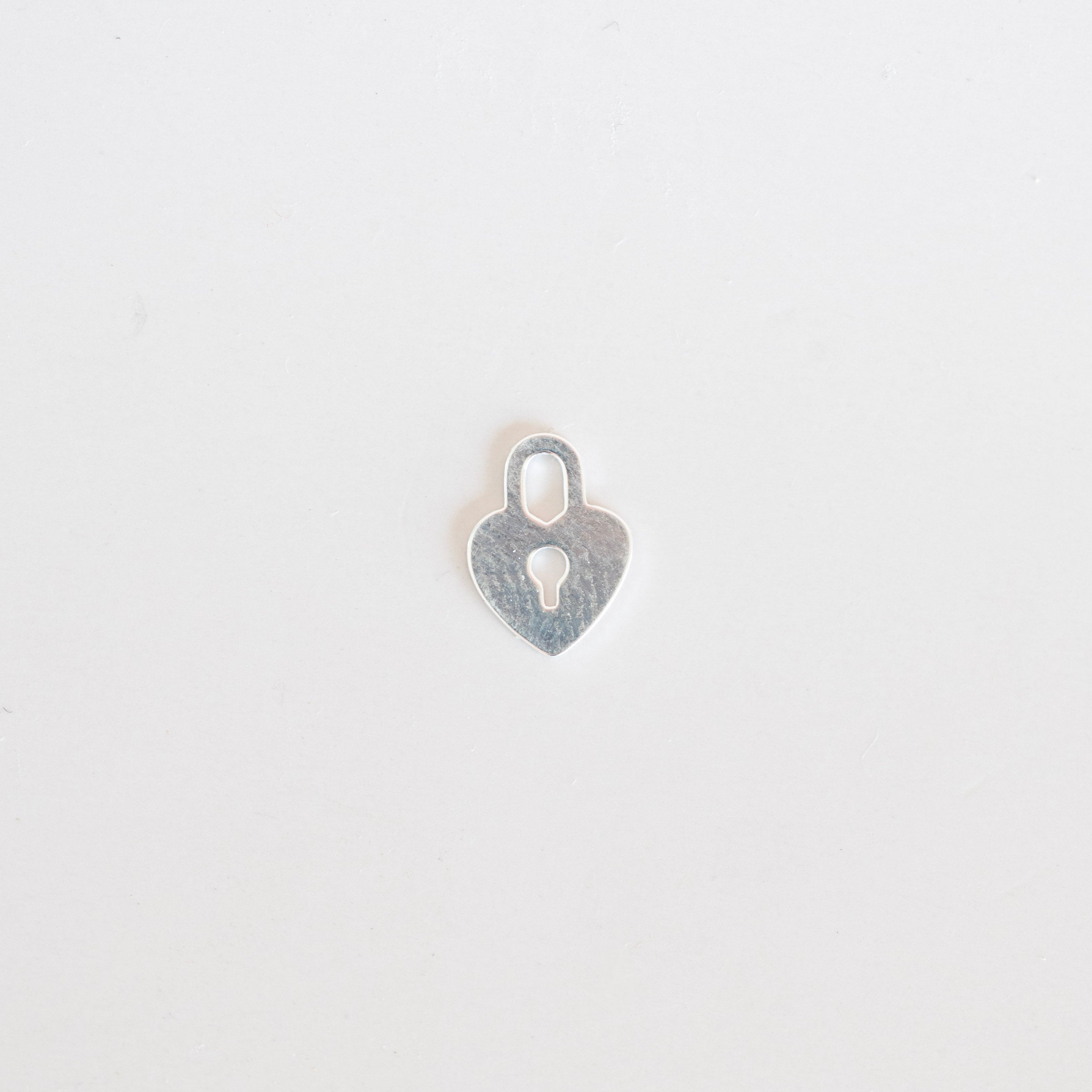 Silver heart-shaped pendant on a light gray background