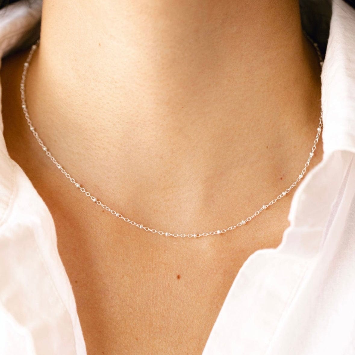 Delicate beaded necklace on a woman's neck (EE7B83C7-CF6F-482B)
