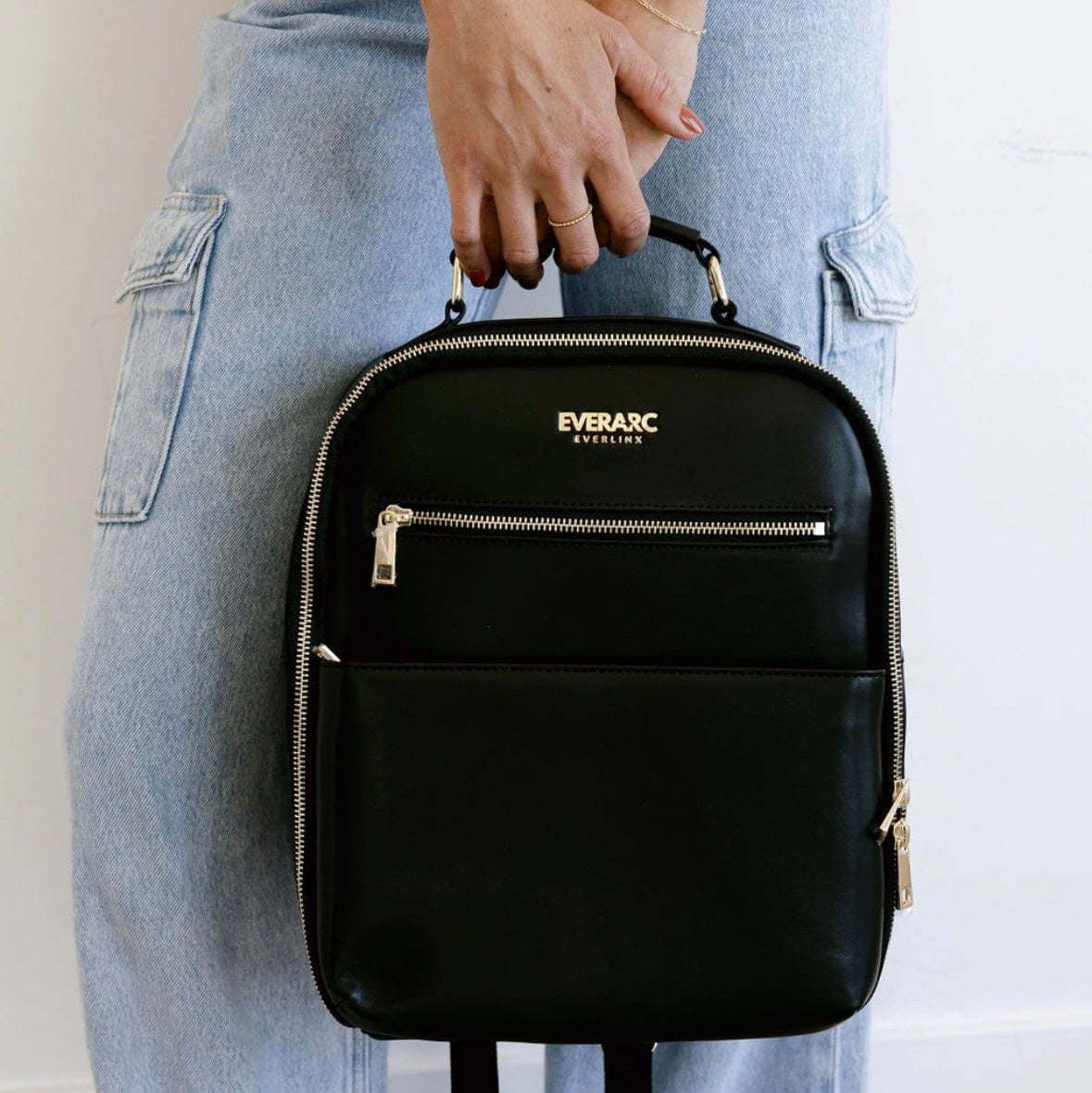 Woman holding black Everbasic backpack