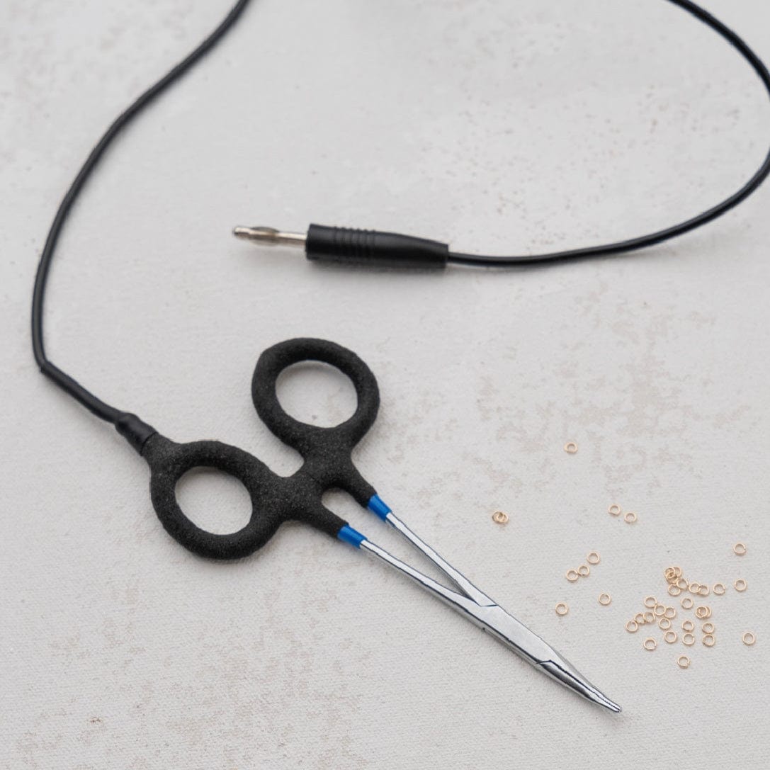 Close-up of black scissors, audio jack, and small rings.