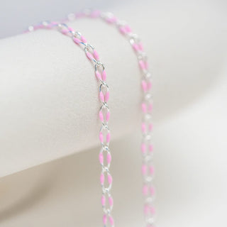 Pink and silver chain necklace on white background.