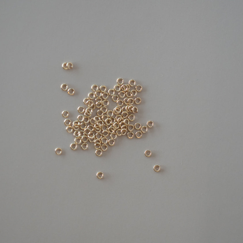 Small gold beads scattered on a gray background