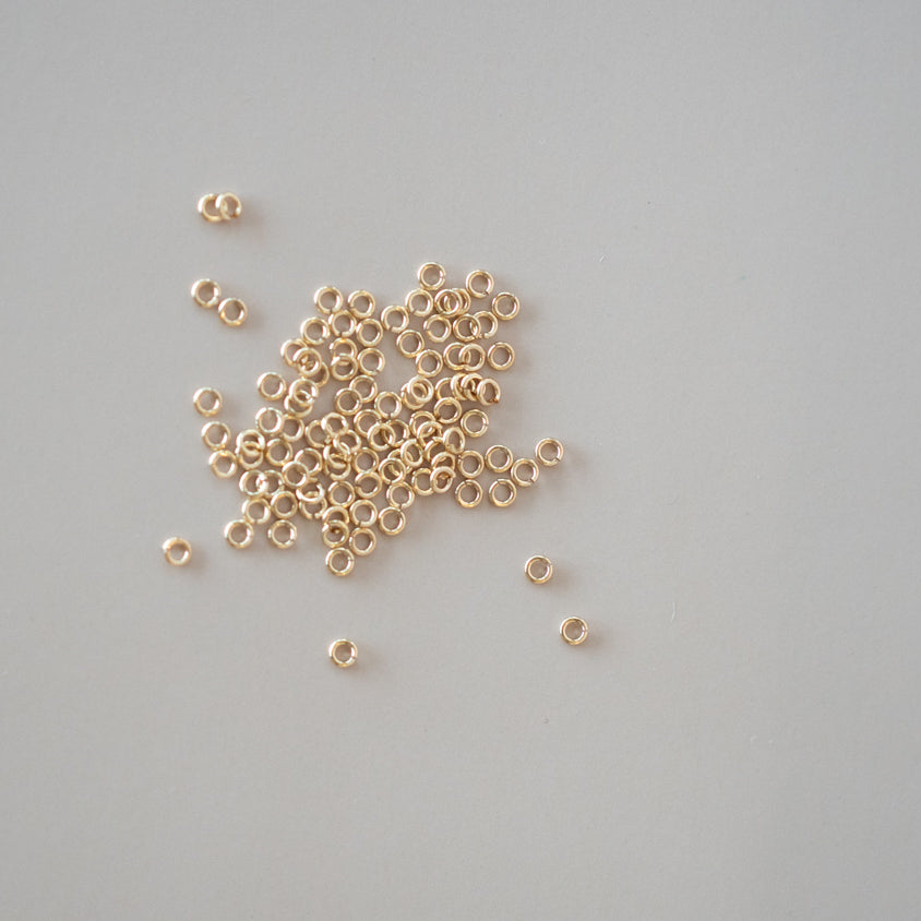 Small gold beads scattered on a gray background