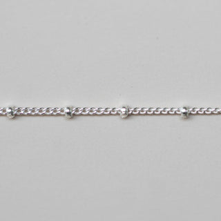 Silver chain bracelet on a light gray background