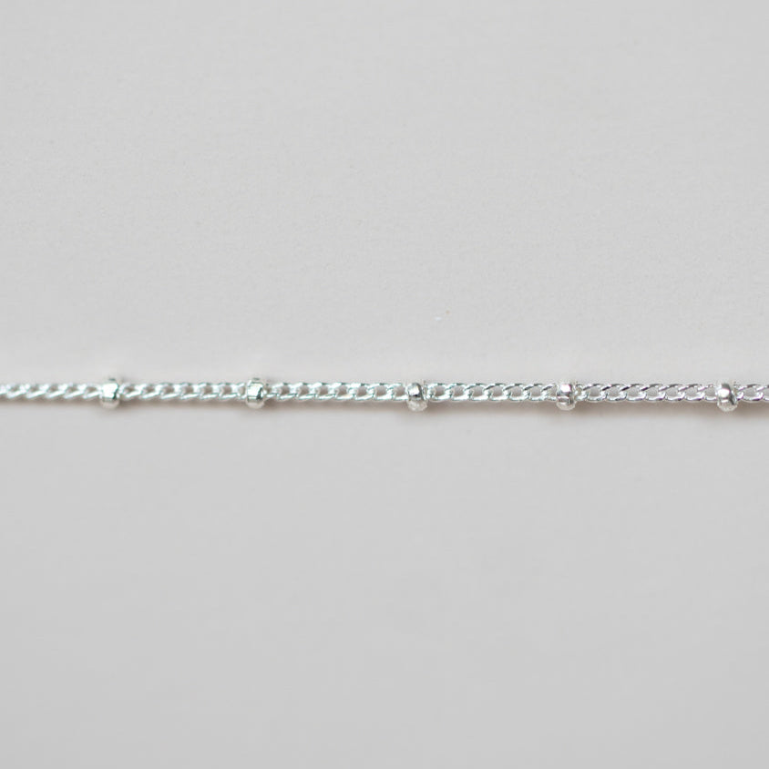 Silver chain on a light gray background