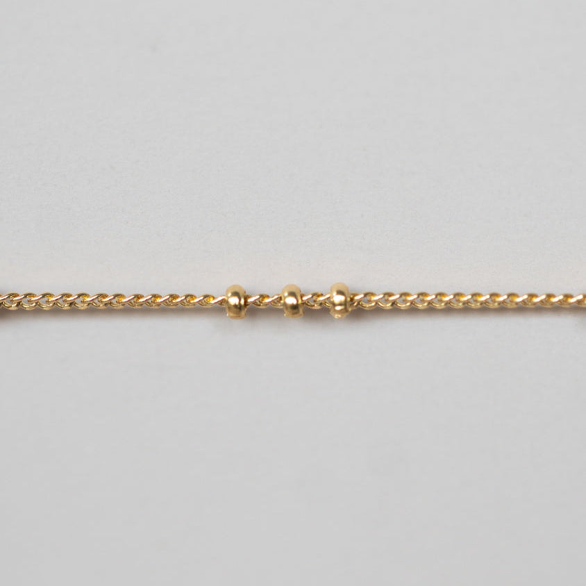 Gold chain on a light gray background