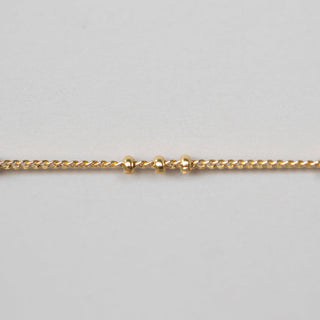 Gold chain on a light gray background