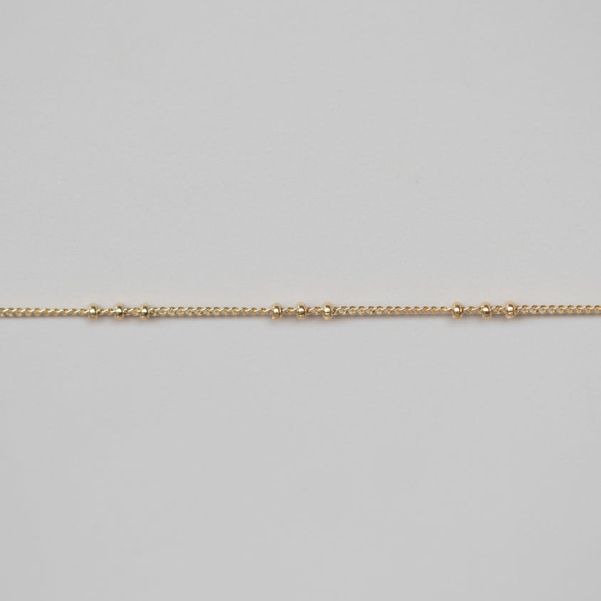 Gold chain on a light gray background