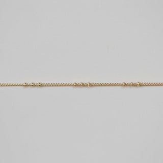 Gold chain on a light gray background