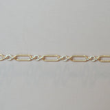 Gold chain bracelet on a light gray background