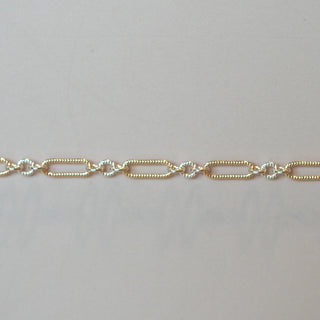 Gold chain bracelet on a light gray background