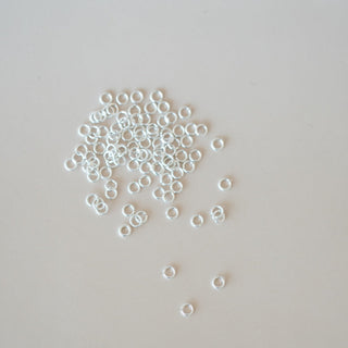Small metal washers scattered on a light gray background