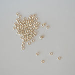 Small gold beads scattered on a gray background