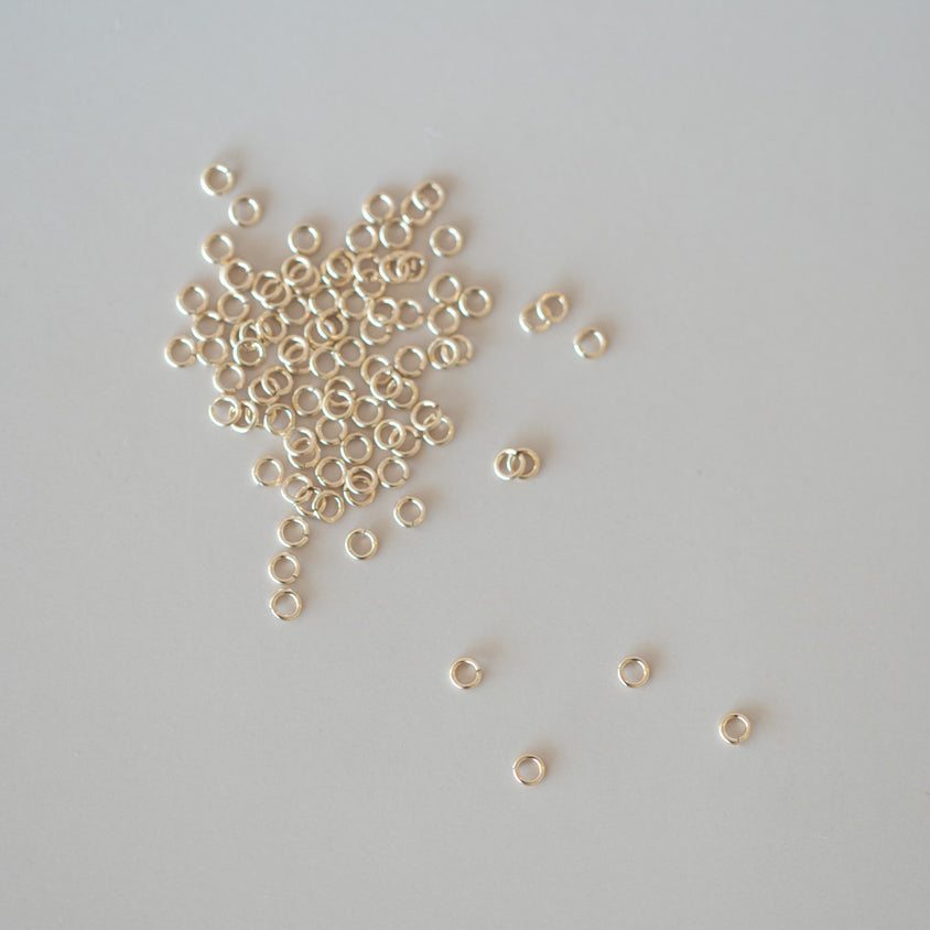 Small gold beads scattered on a gray background