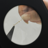 Jewelry chain repair under magnification, screenshot May 12, 2025.