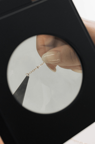 Jewelry chain repair under magnification, screenshot May 12, 2025.