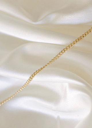 Gold chain necklace on silk