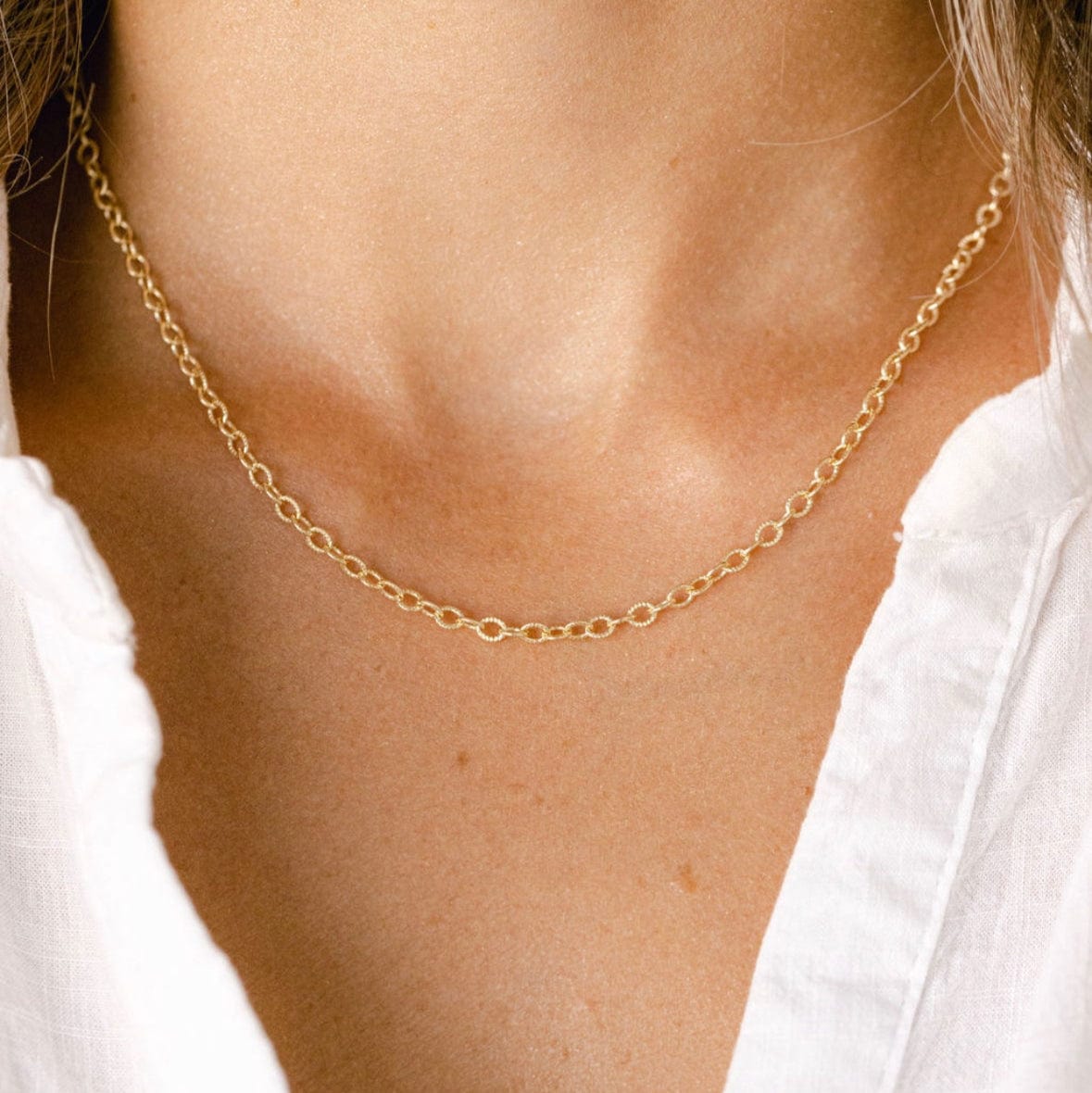 Gold chain necklace on a woman, image_118758f0