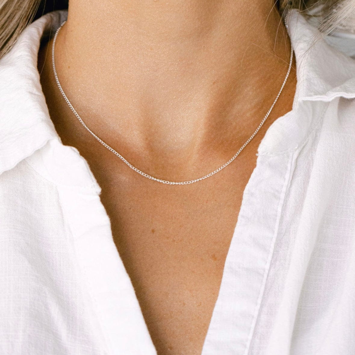Silver necklace on woman's neck