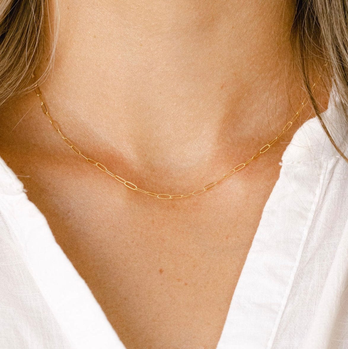 Gold chain necklace on a white shirt