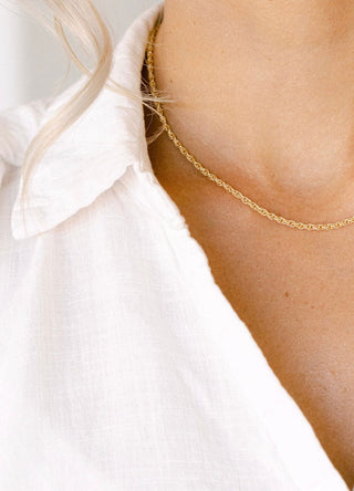 Gold chain necklace on a white shirt
