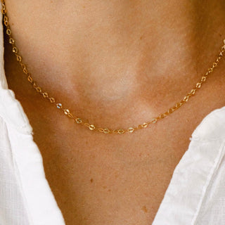 Gold chain necklace on white shirt