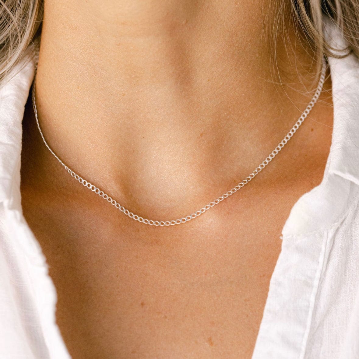 Silver chain necklace on white shirt