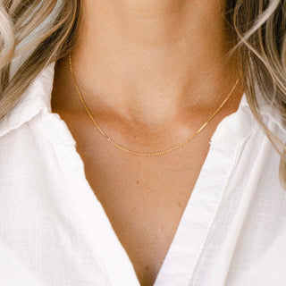 Gold necklace on white shirt