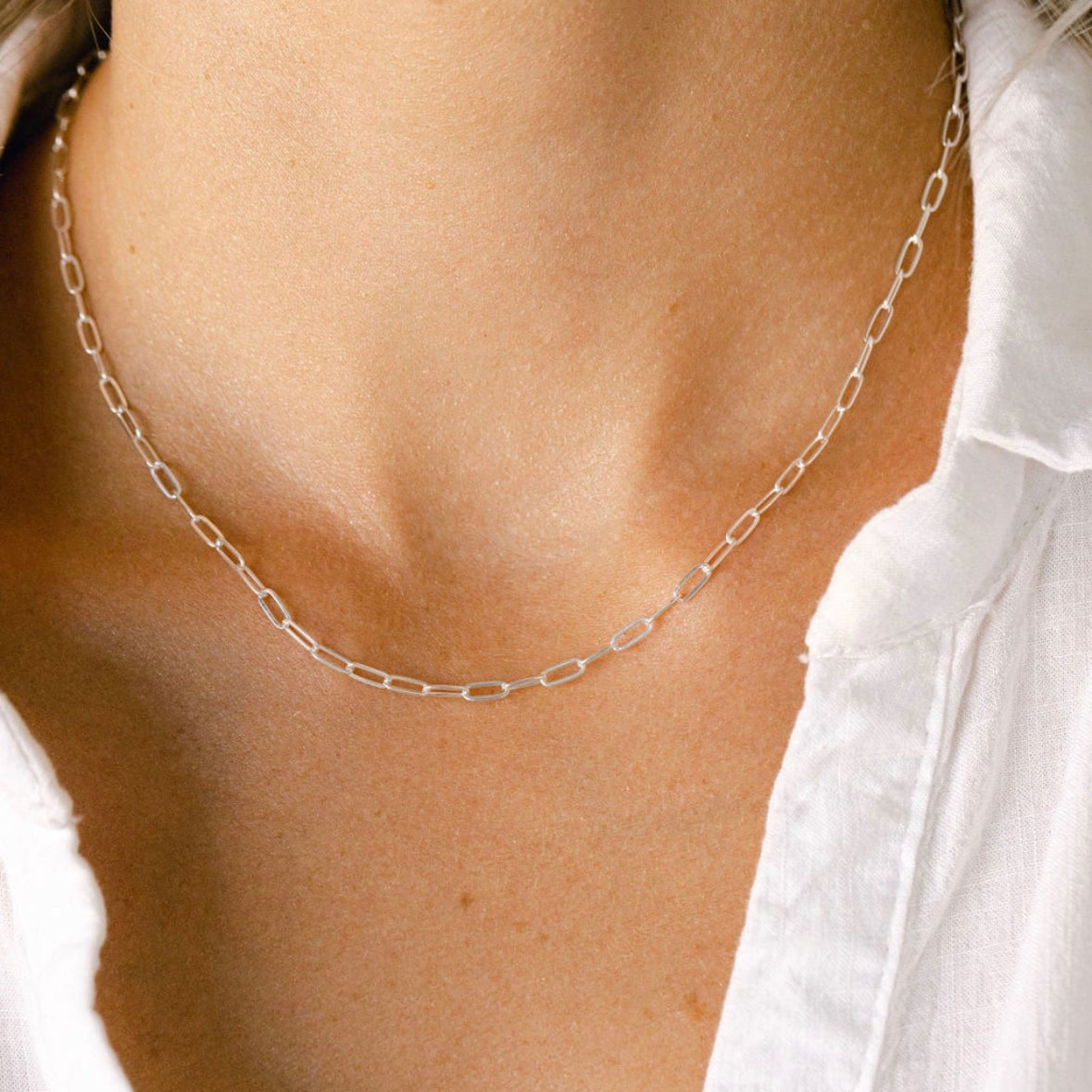 Silver chain necklace on white shirt