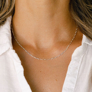 Delicate silver necklace on white shirt