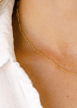 Gold chain necklace on a woman's neck