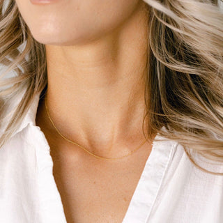 Woman wearing gold necklace, image_6824e8c0-7053-4987-94ed-407e5fbcf378