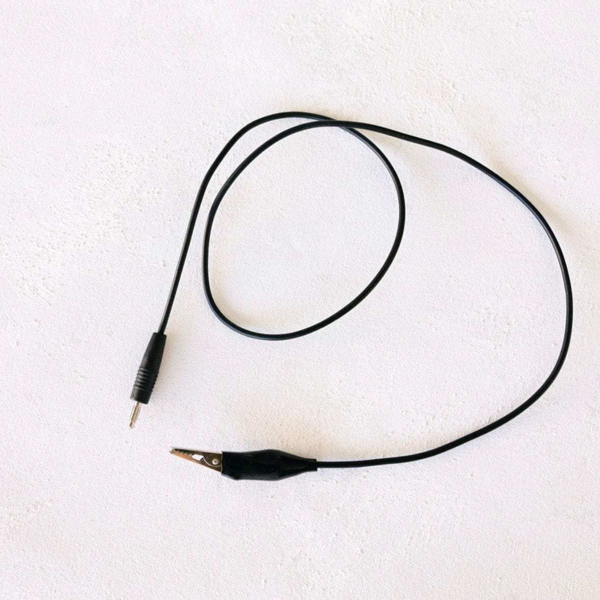 Black alligator clip and wire on white background