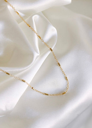 Gold necklace on white satin