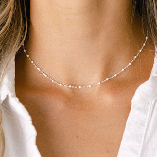 Delicate pearl necklace on woman in white shirt