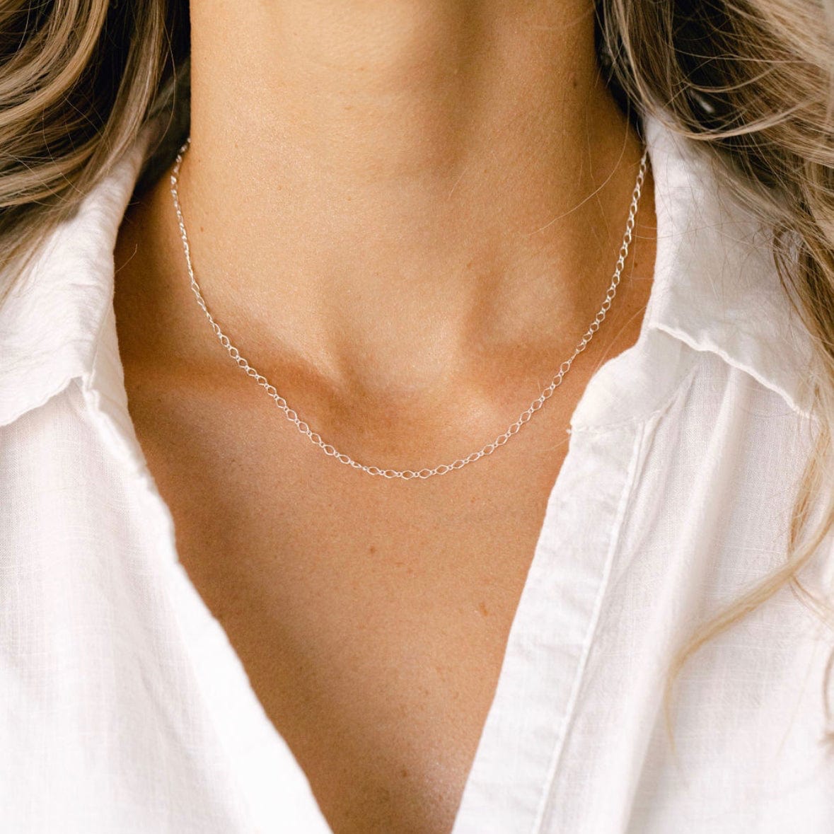 Silver chain necklace on white shirt