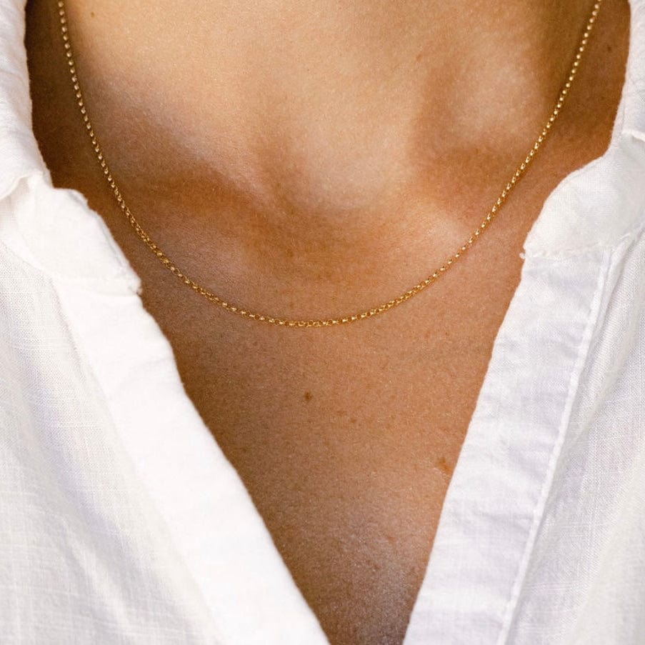 Gold chain necklace on white shirt