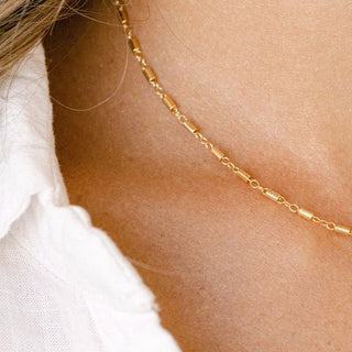 Gold necklace on a person's neck