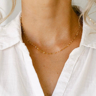 Gold chain necklace on white shirt