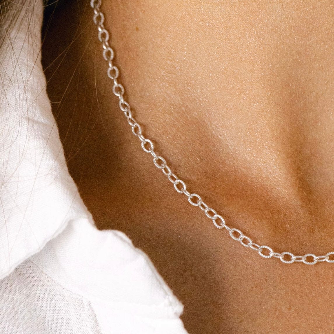 Silver chain necklace on woman's neck