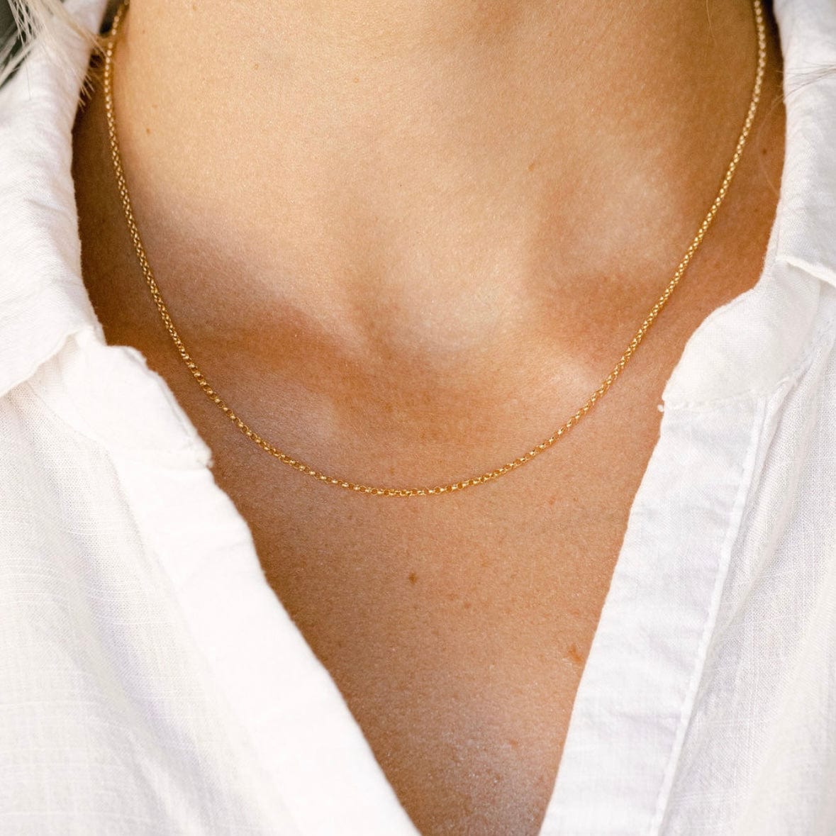 Gold chain necklace on white shirt
