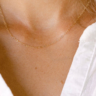Gold chain necklace on a woman's neck