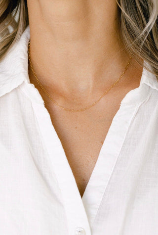 Gold chain necklace on white shirt