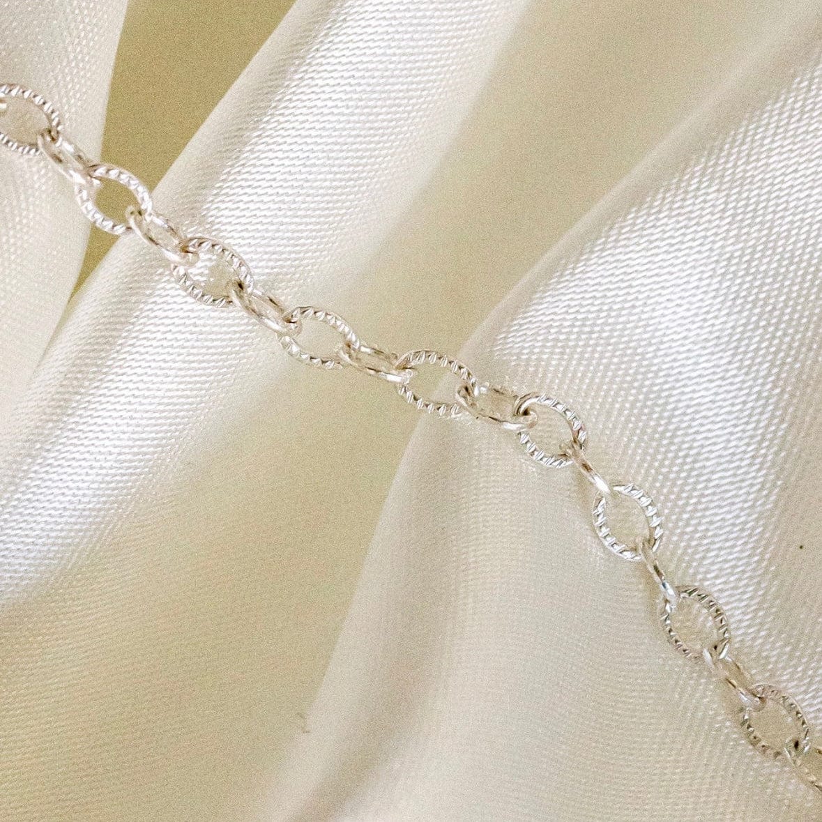 Silver chain on satin fabric