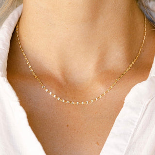 Gold chain necklace on a woman's neck
