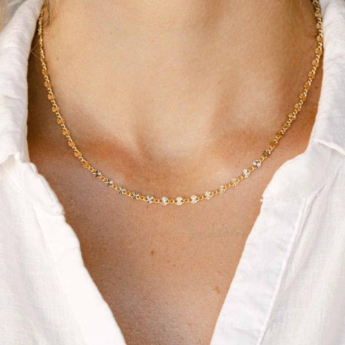 Gold necklace on a person's neck
