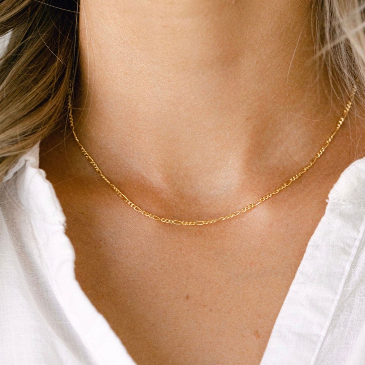 Gold chain necklace on a white shirt
