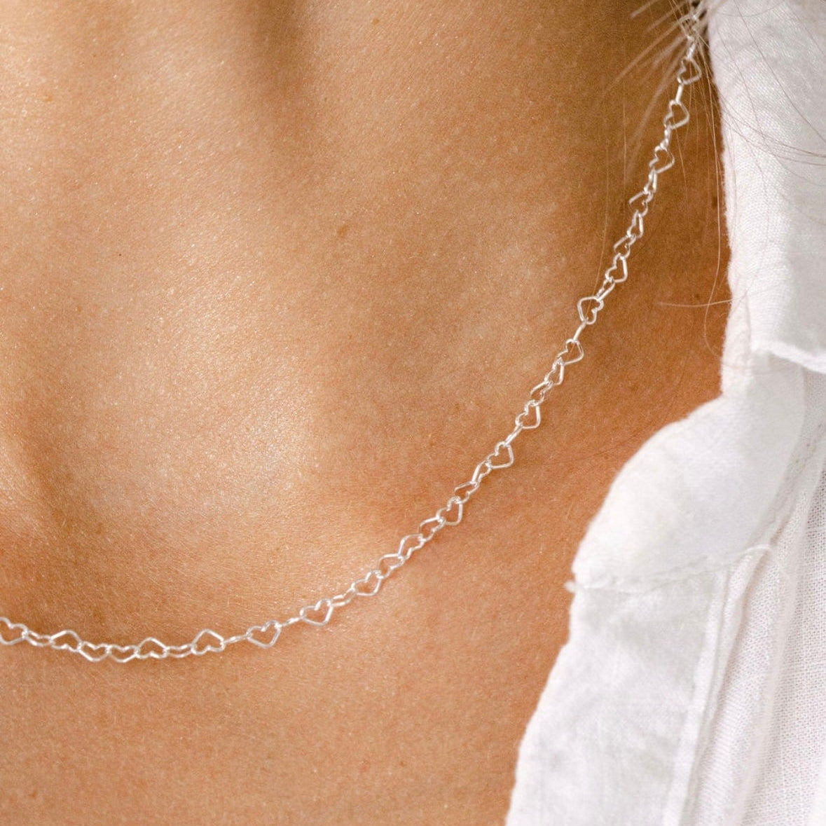 Heart charm necklace on a woman